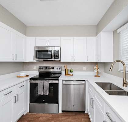 a white kitchen with stainless steel appliances and white cabinets