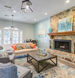 A living room with a stone fireplace and a couch. at Westbury Creek, Augusta