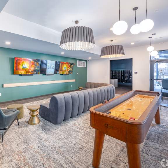 A room with a pool table and a row of chairs.