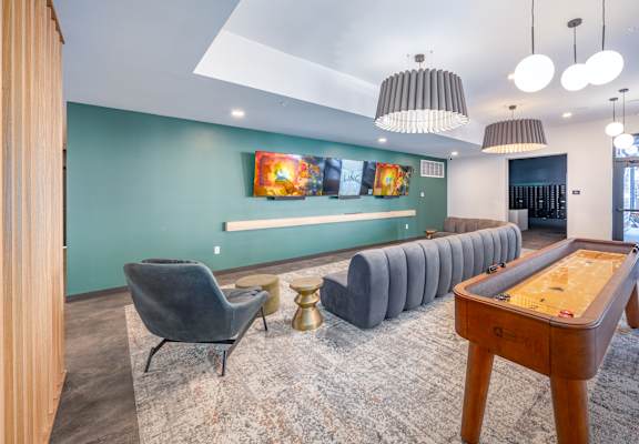 A room with a pool table and a row of chairs.