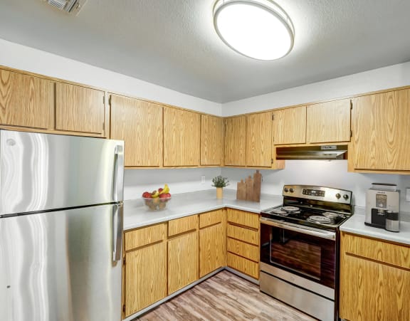 a kitchen with wooden cabinets and stainless steel appliances
