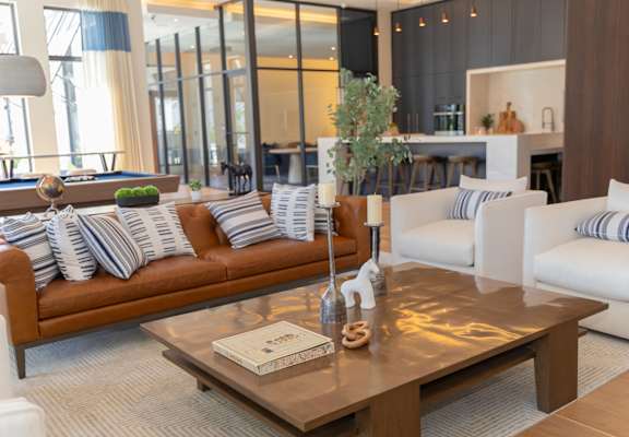 A modern living room with a brown leather couch and a wooden coffee table.