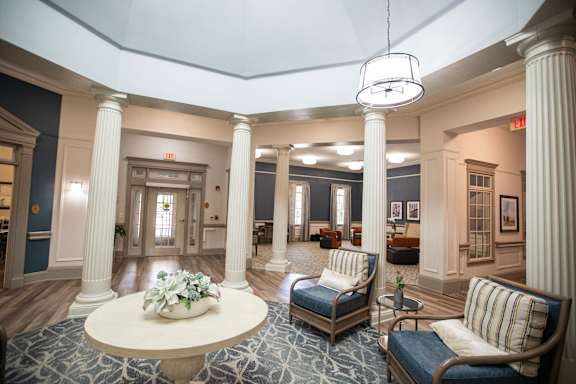 A large room with a circular table and chairs.