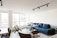 A living room with a blue couch and a wooden table.