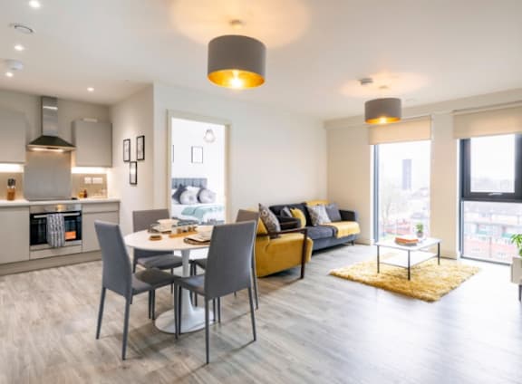 a living room and dining room with a table and chairs at The Trilogy Apartments, Manchester, M15 4RU