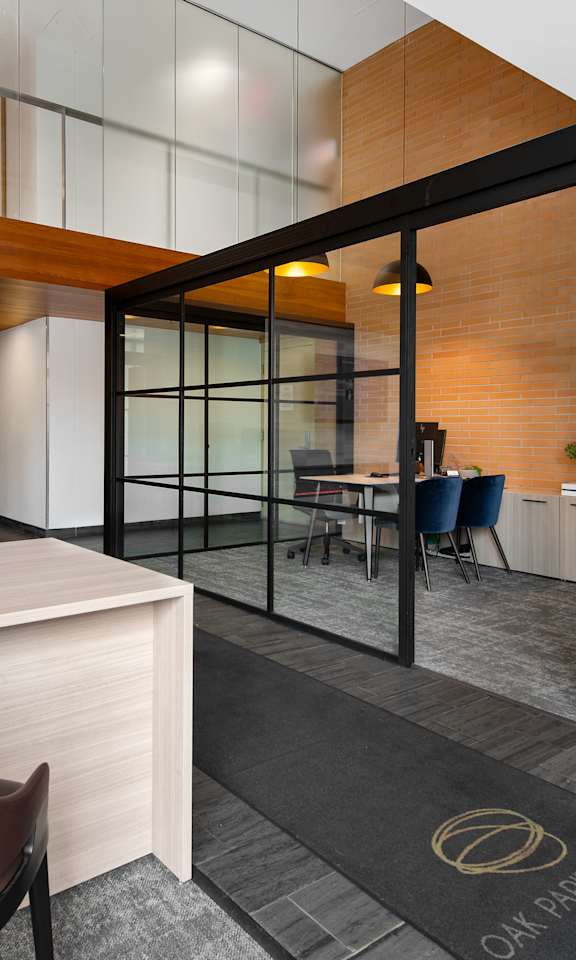 A modern office space with a brown leather chair and a wooden desk.