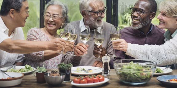 a group of people sitting around a table drinking wine