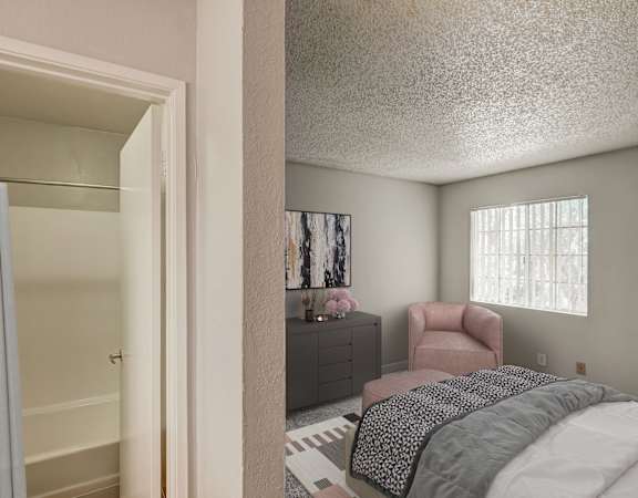 A bedroom with a bed, chair, and a cabinet.