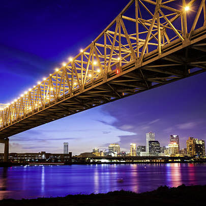 A bridge with lights on it over a body of water.