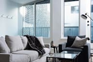 A modern living room with a grey sofa and a glass table.