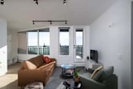 A living room with a brown couch and a green couch.