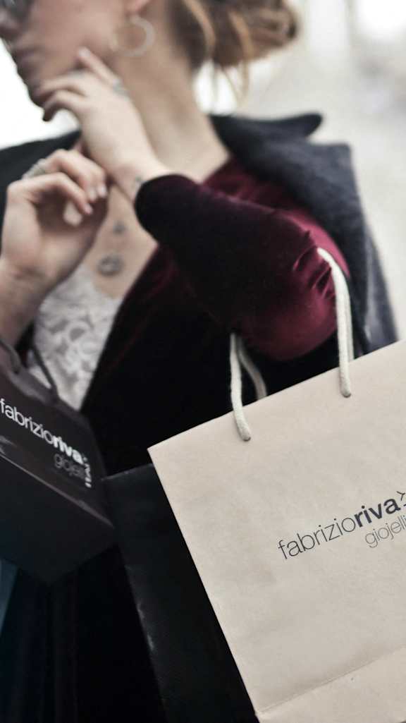 a woman holding shopping bags and talking on her cell phone