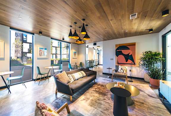 A modern living room with a black couch and a wooden floor.