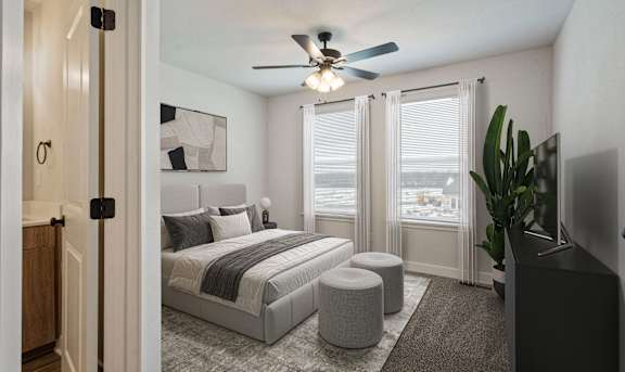 A bedroom with a bed, a ceiling fan, and a window with blinds.