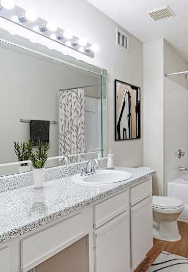 A bathroom with a white sink and a white toilet.