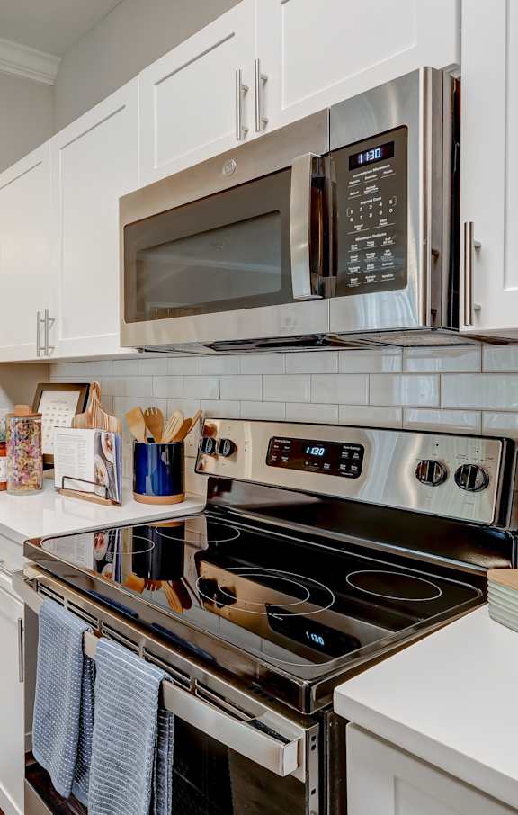 a kitchen with white cabinets and stainless steel appliances