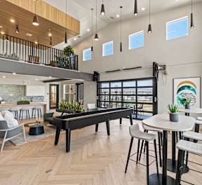 A kitchen with a table and chairs and a microwave above the stove.