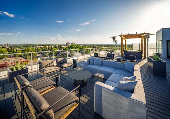 A rooftop patio with a table and chairs.
