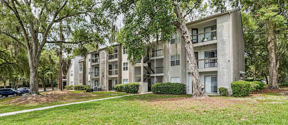 Apartment building surrounded by trees and grass.
