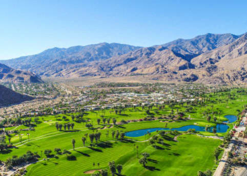 a view of a golf course with mountains in the background