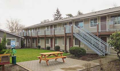 an exterior view of an apartment building with a picnic table