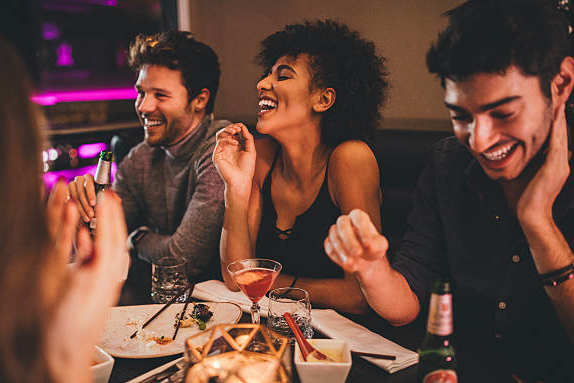 A group of people are enjoying a meal together at a restaurant.
