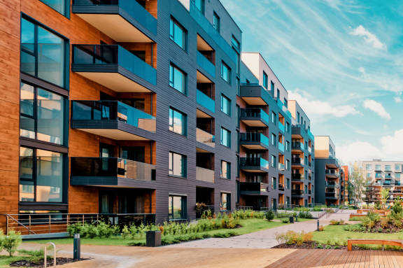 A modern apartment complex with balconies and a wooden walkway.