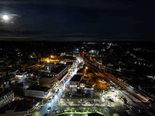 A nighttime cityscape with a full moon in the sky.