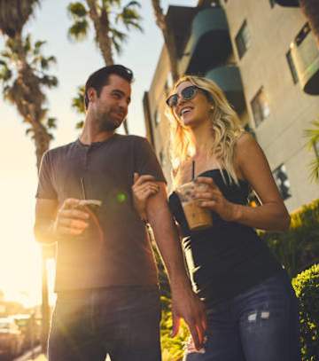 a couple walking with a cop of coffee at Oasis Apartments, Burbank