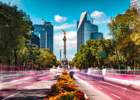 A long exposure shot of a city street with a monument in the background.
