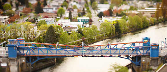 A blue bridge over a river in a town.