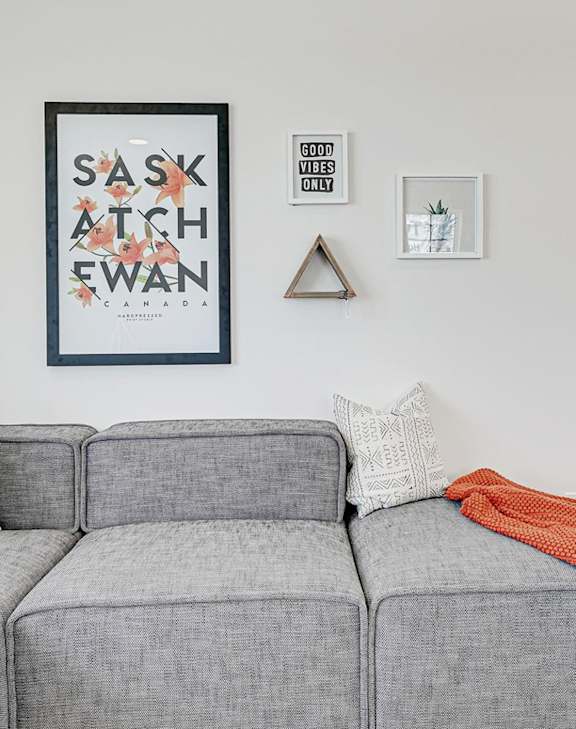 A grey couch with pillows and a blanket is on a patio.