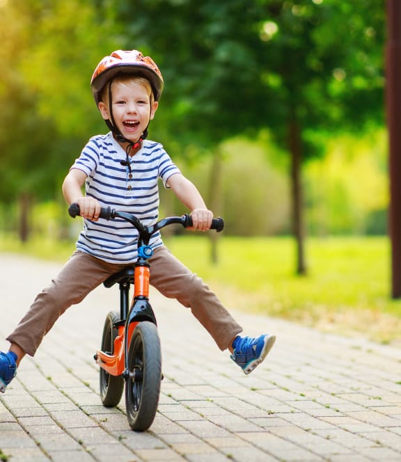 little boy riding a bike in the park