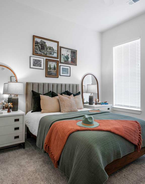 a bedroom with a bed and a dresser with a mirror on top of it
