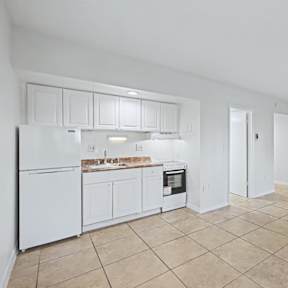 A kitchen with white appliances and cabinets.