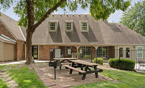 A house with a picnic table in front of it.
