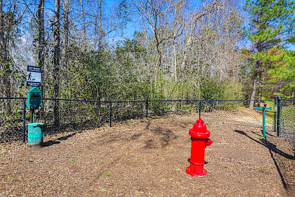 a red fire hydrant in front of a fence