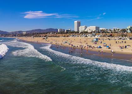 A beach scene with people enjoying the sun and waves.