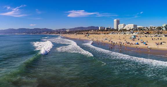 A beach scene with people enjoying the sun and waves.