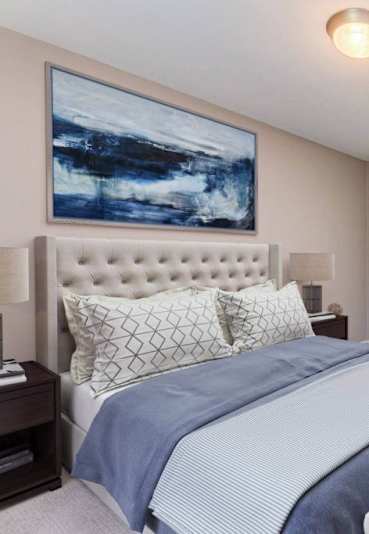 Master bedroom with tufted headboard and abstract artwork at Canterbury Square Apartments, Troy, MI 48083