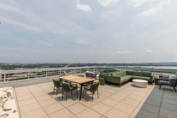 A patio with a table and chairs overlooking a body of water.