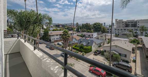 a view of a city from a balcony with palm trees