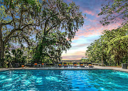 a swimming pool with a colorful sky in the background