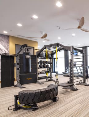 a spacious fitness room with cardio equipment and weights