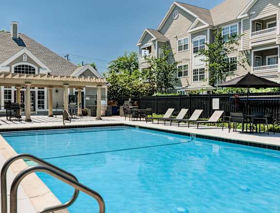 A pool with a metal railing and a black umbrella.