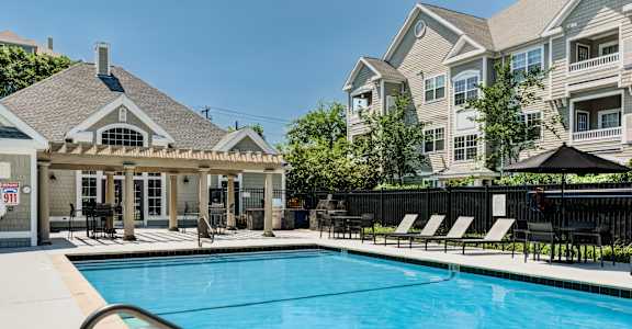 A pool with a metal railing and a black umbrella.