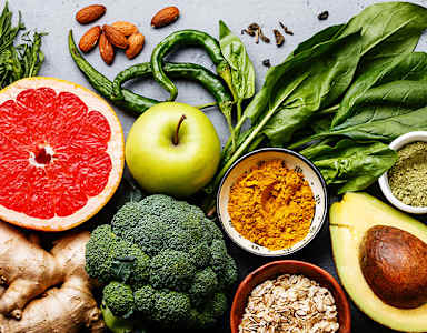 A variety of healthy foods including fruits, vegetables, and grains are displayed.