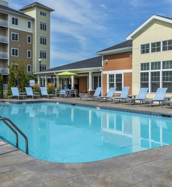 A large swimming pool in front of a building with a sun lounger at Axis at Lakeshore Apartments, Massachusetts