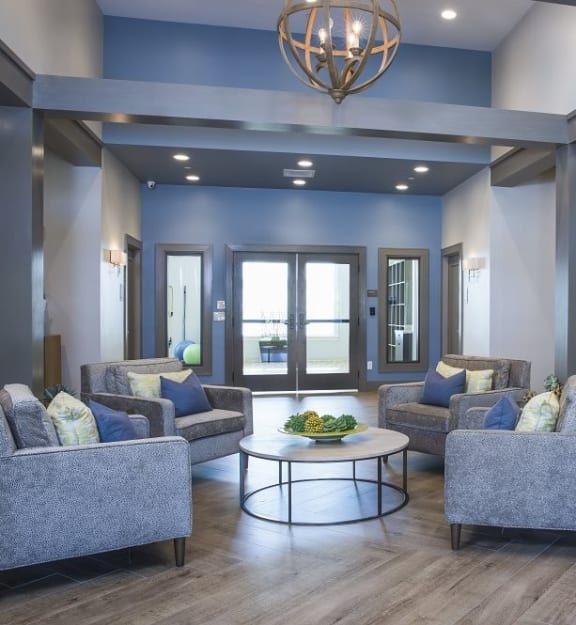 A living room with grey couches and a round table with a bowl of fruit on it at Axis at Lakeshore Apartments, Massachusetts, 02324