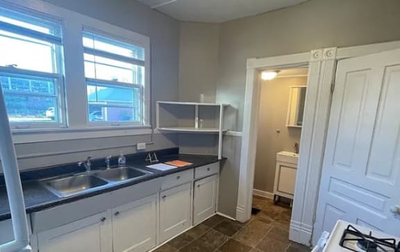a kitchen with a stove top oven next to a sink